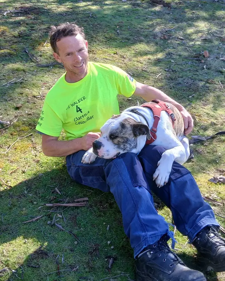 BJ Walker sitting on the grass with his foster dog